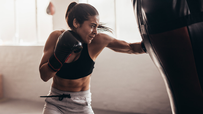 Fit woman hitting punching bag