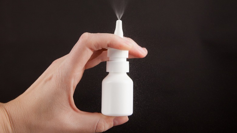 hand holding and pumping nasal congestion spray