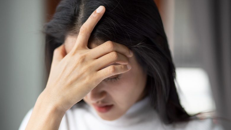 lightheaded woman holding head