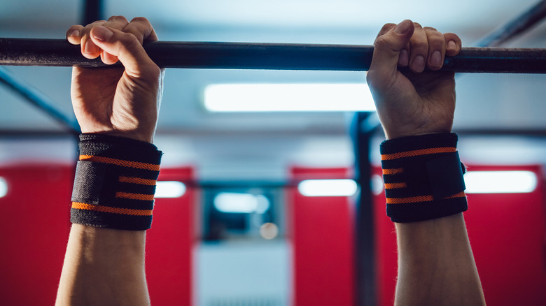 hands gripping pull up bar