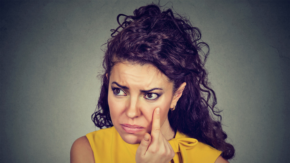 Woman pulling down eyelid checking her eye