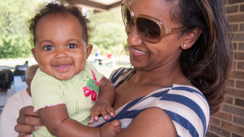 Smiling mother with dimples holding her young child