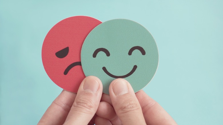 Paper happy and sad faces representing bipolar disorder