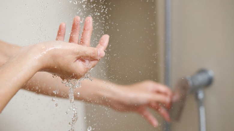 Hands under shower stream