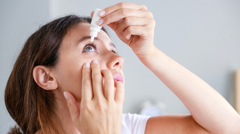woman putting in eye drops