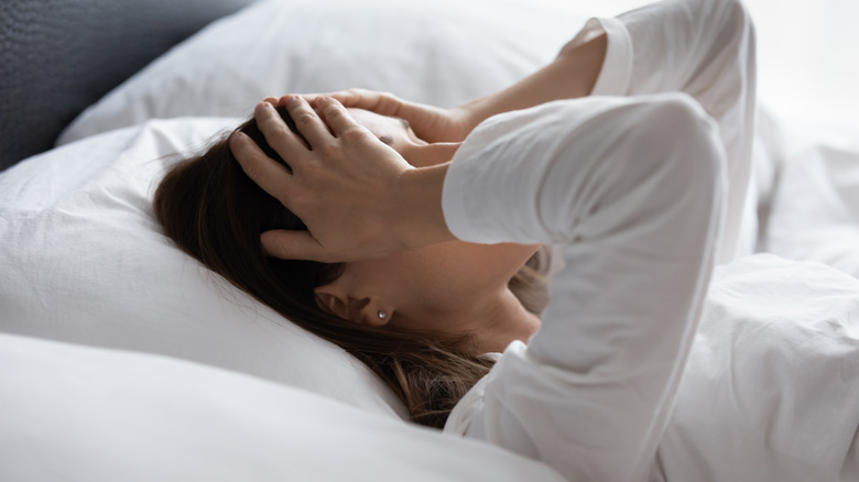 Close up of woman lying in bed in early morning 