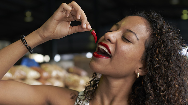 woman eating a chili pepper