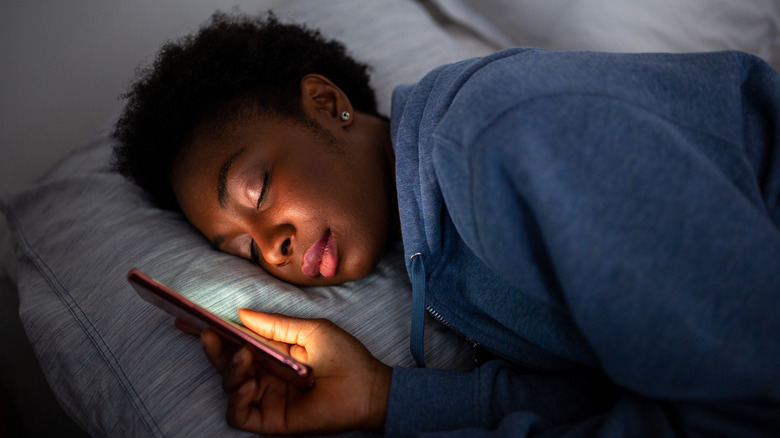 Person asleep holding phone