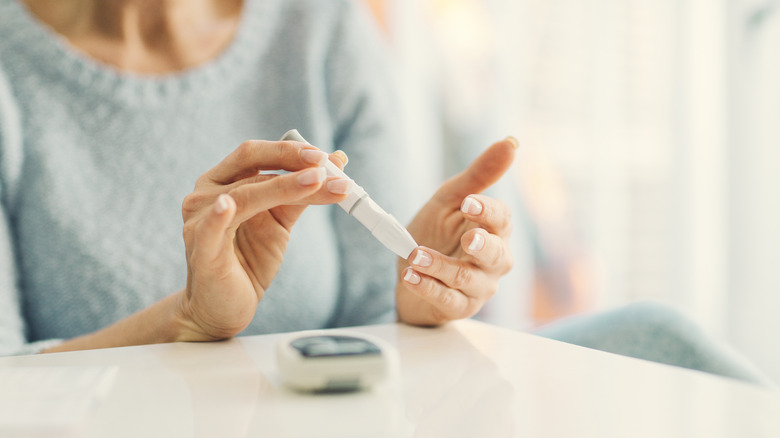 Woman testing blood sugar at home