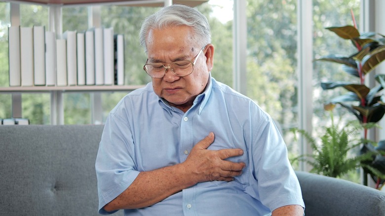 Man holding chest in pain