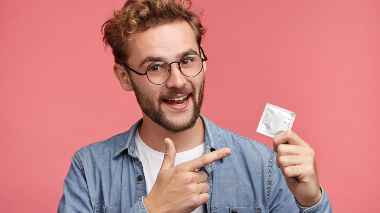 young man holding condom