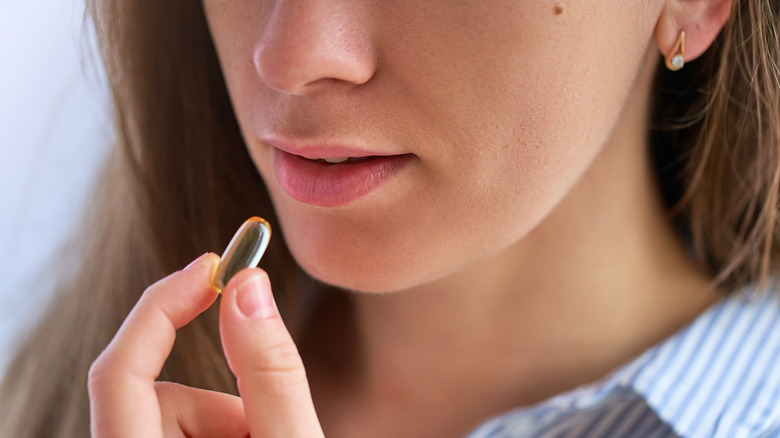 woman taking vitamin D supplement