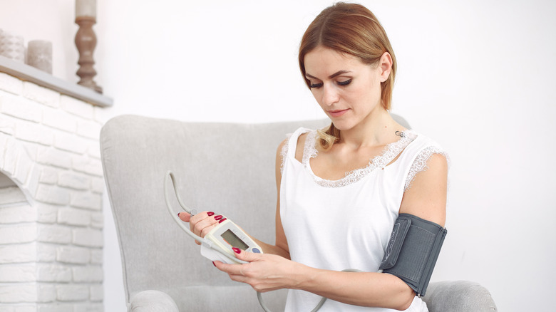woman using blood pressure cuff