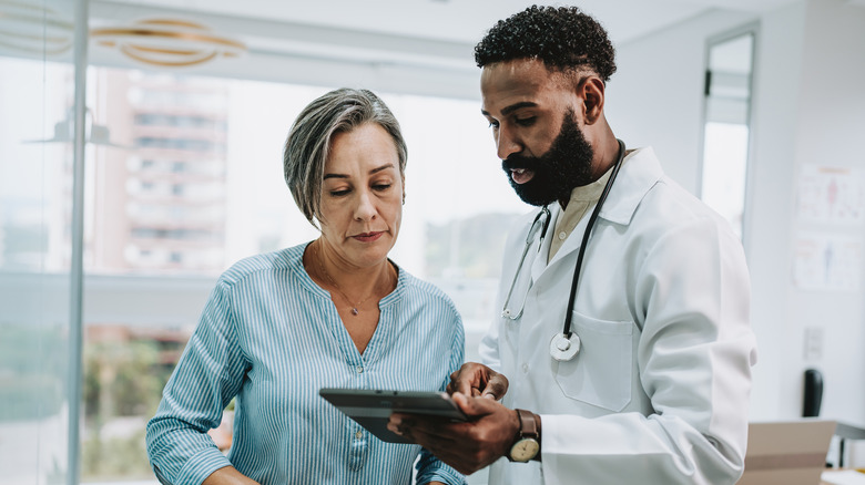 doctor sharing information on tablet with woman patient