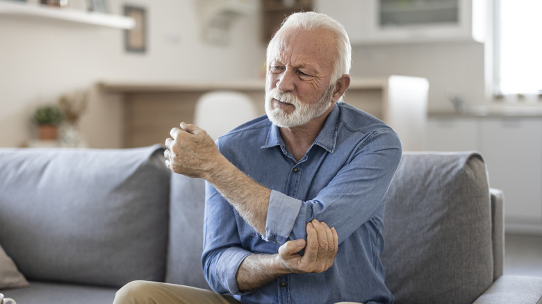 man feeling his sore elbow