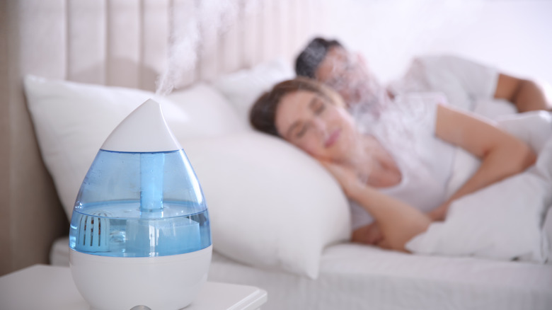 Couple sleeps with a humidifier running on the nightstand