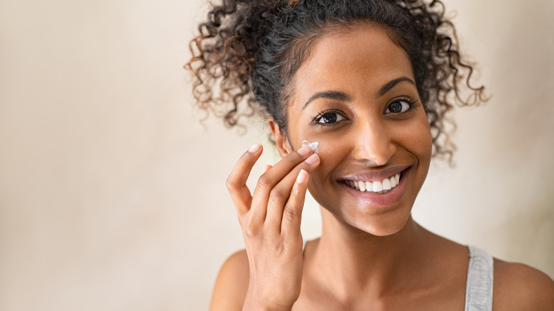 Woman applying skincare to her face