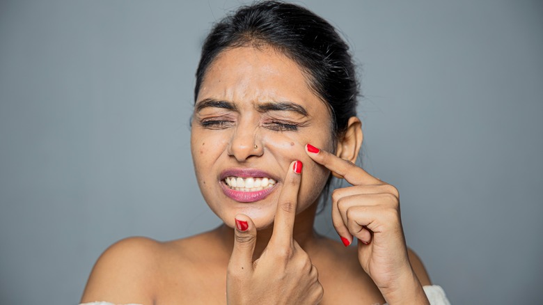 Woman touching her face with a pained expression