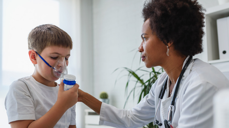 doctor helping young boy with nebulizer