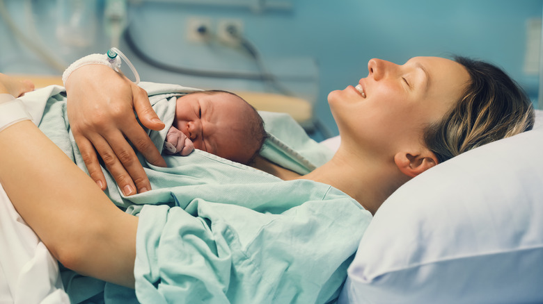 Woman in hospital bed holding baby