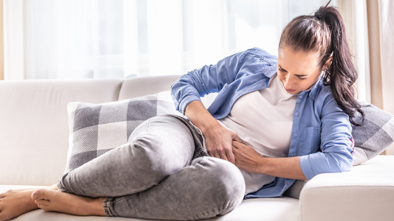 Woman on a couch in pain with gallbladder attack