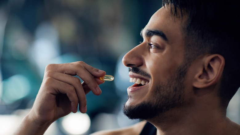 smiling man taking pill