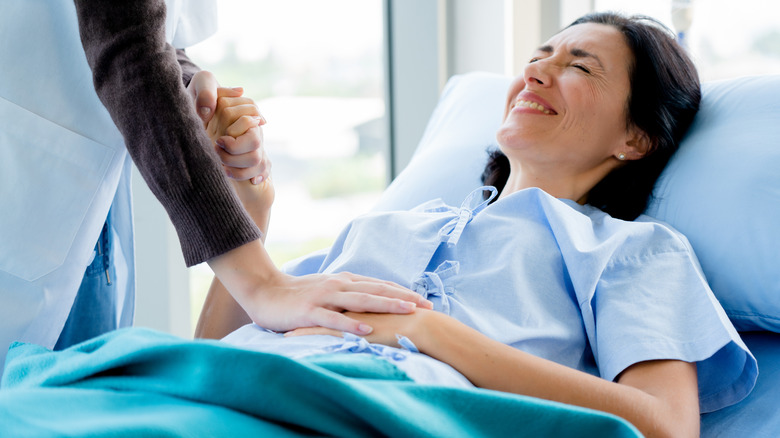 Pained woman in hospital bed