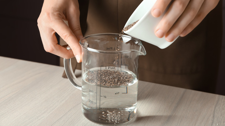 Woman adding chia seeds to water