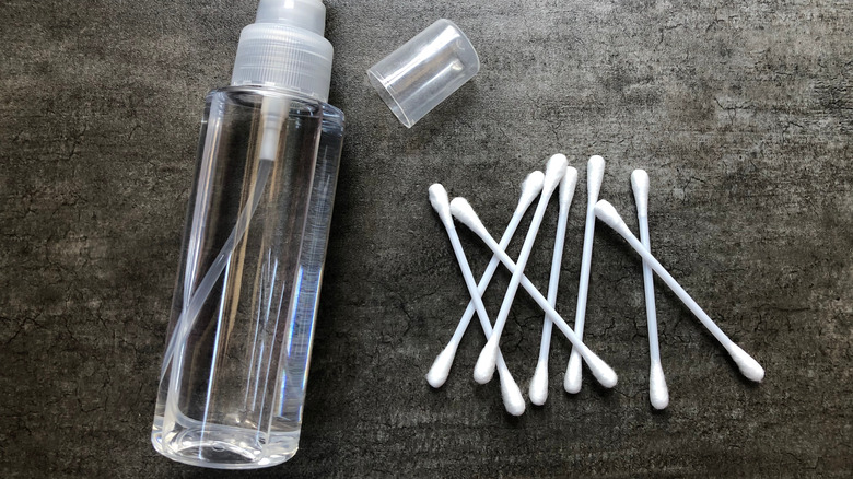 Cotton swabs next to a bottle of water