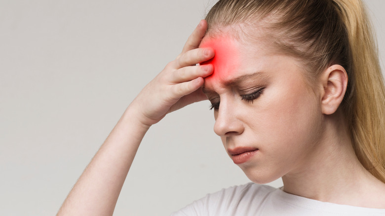 woman holding her head in pain