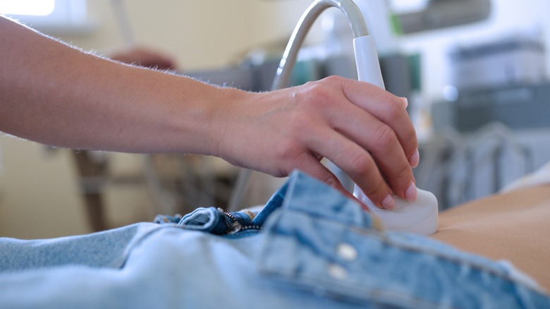 doctor performs examination of abdomen 