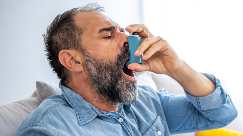 man using inhaler at home