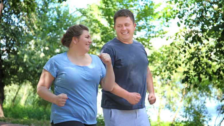 overweight couple exercising outdoors