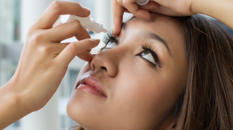 woman puts in eye drops