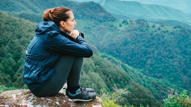 woman sits on mountain