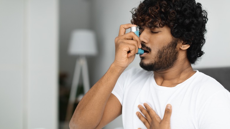 man using asthma inhaler