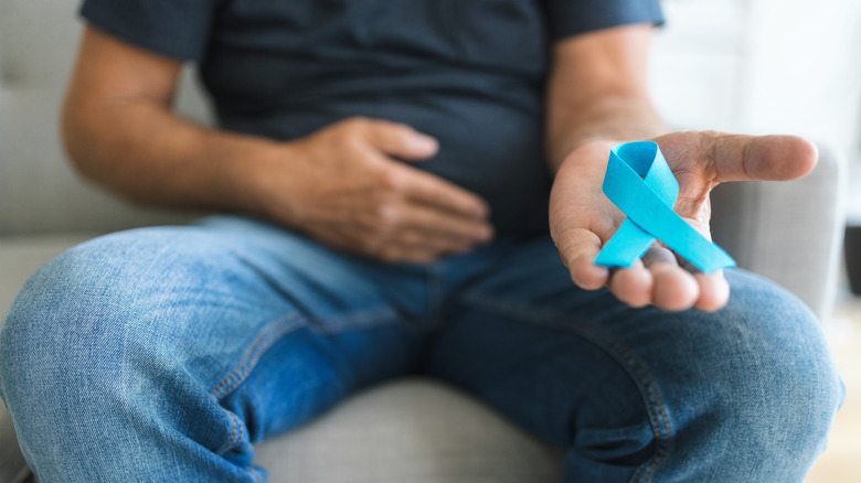 Man holding blue cancer ribbon