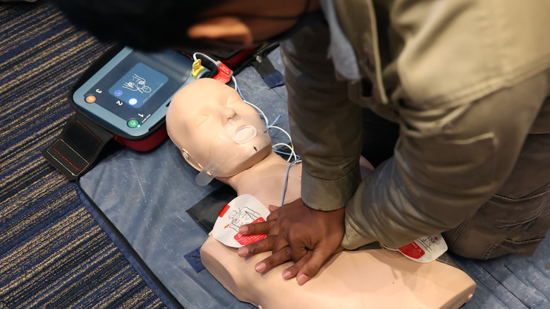 Man practicing CPR with an AED