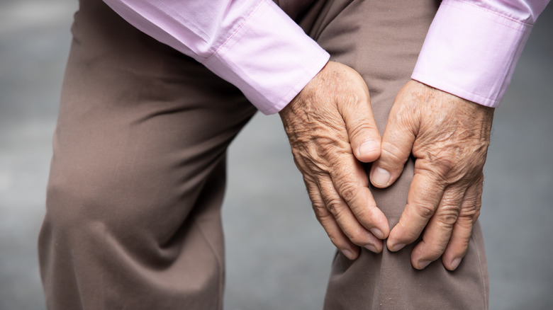 A man holds his knee