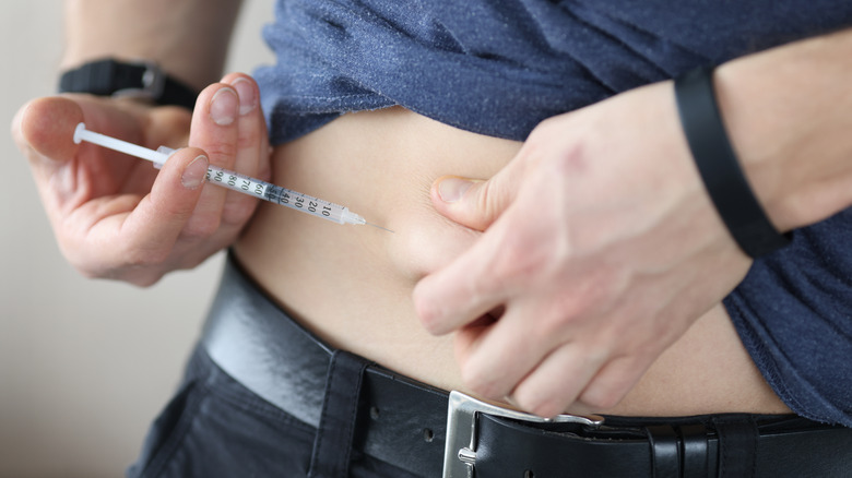 male injecting insulin in stomach