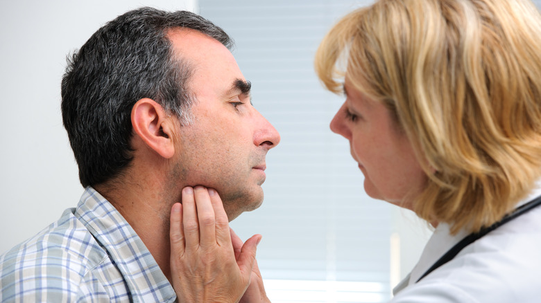 man getting throat checked by doctor