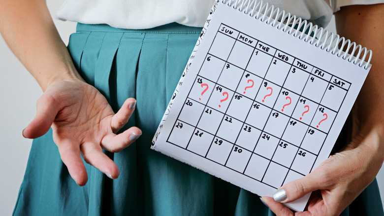 Woman holds period calendar
