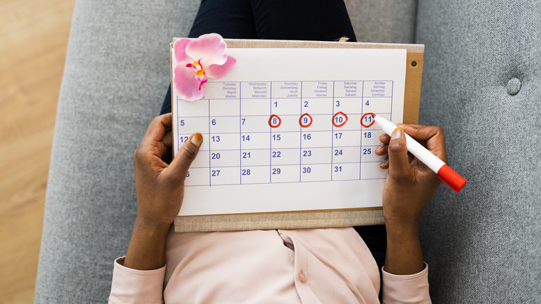 Woman marking menstrual calendar