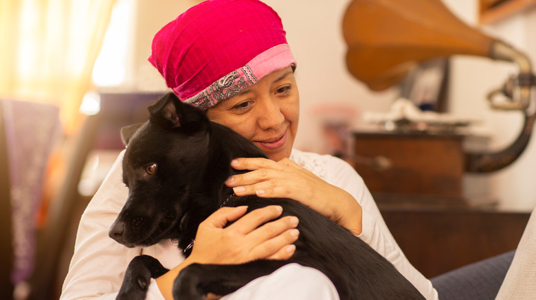 Woman hugging a black dog