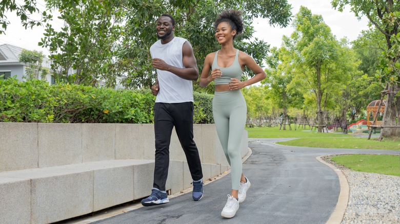 happy couple running in park together