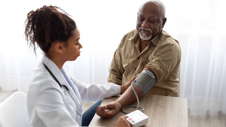 Doctor taking patient blood pressure