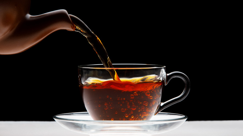Teapot pouring tea into mug