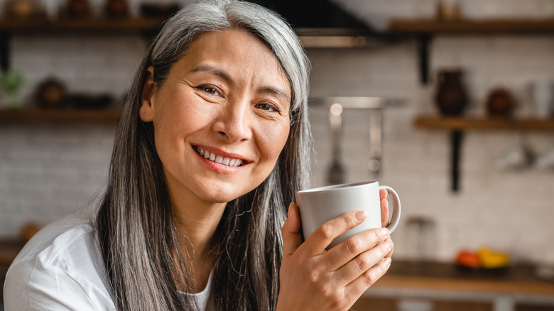 Smiling older woman holding mug