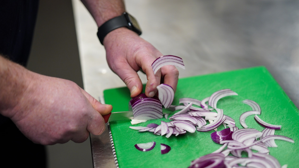 Chef Colin Woodward chops an onion as he prepares meals at the Mill restaurant on October 28, 2020 in Stokesley, England.