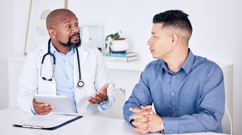 A doctor talking to a male patient